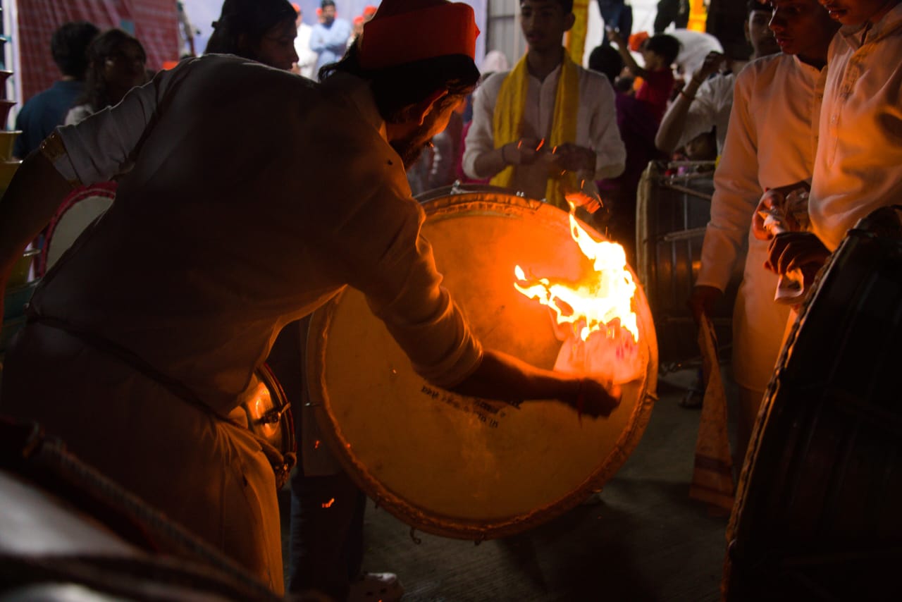 Man hitting drum over fire